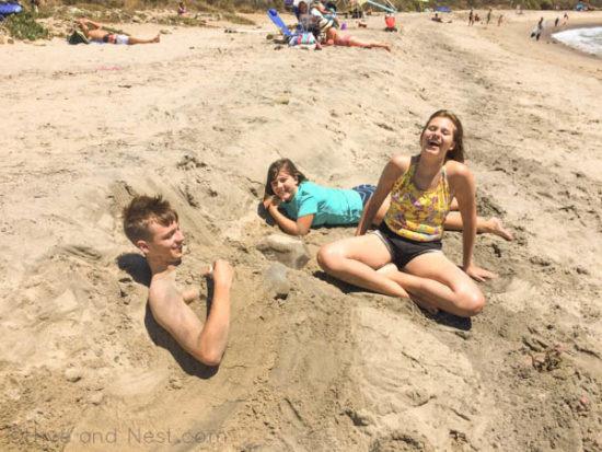 kids laughing buried sand